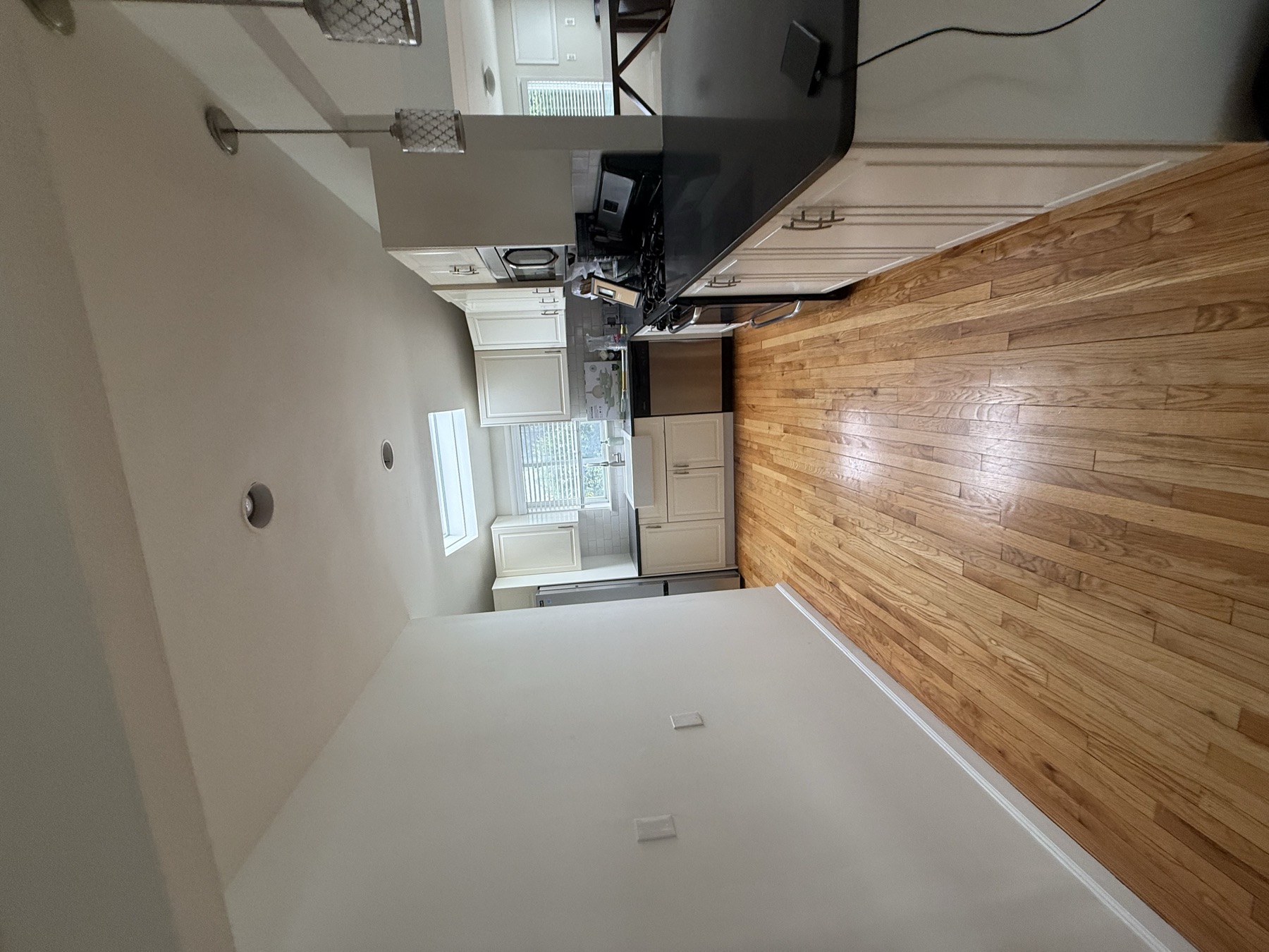 Clean kitchen and hardwood floor in a newly purchased home before move-in
