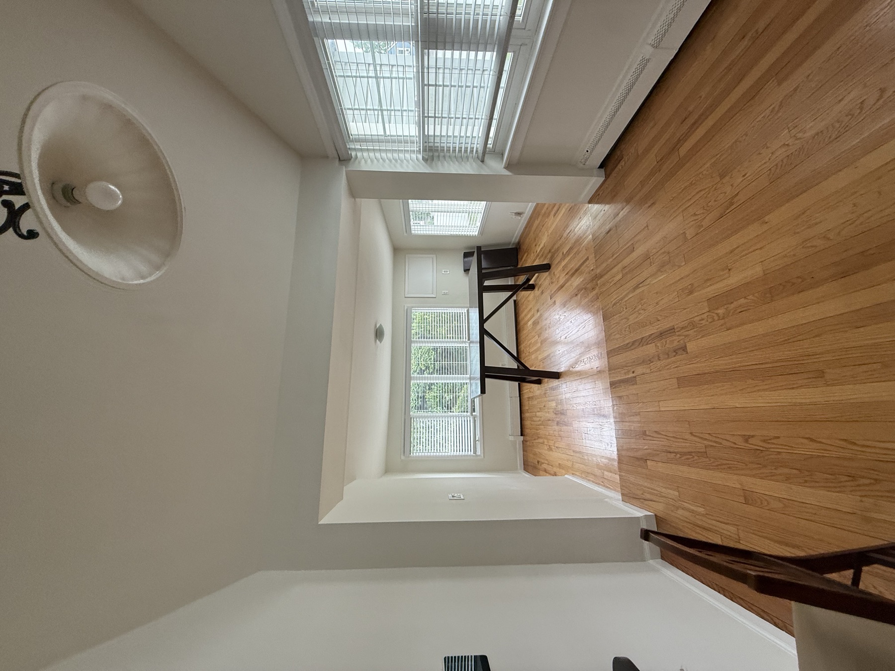 Clean living and dining area with polished hardwood floors before a family moves into a newly purchased New York City home