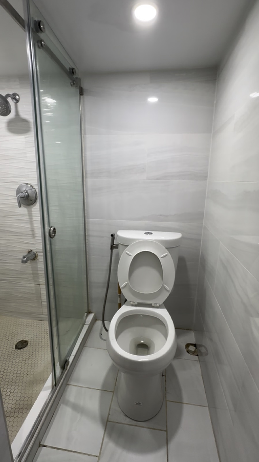 Clean bathroom, glass shower, toilet, and tile after move-out cleaning in Queens