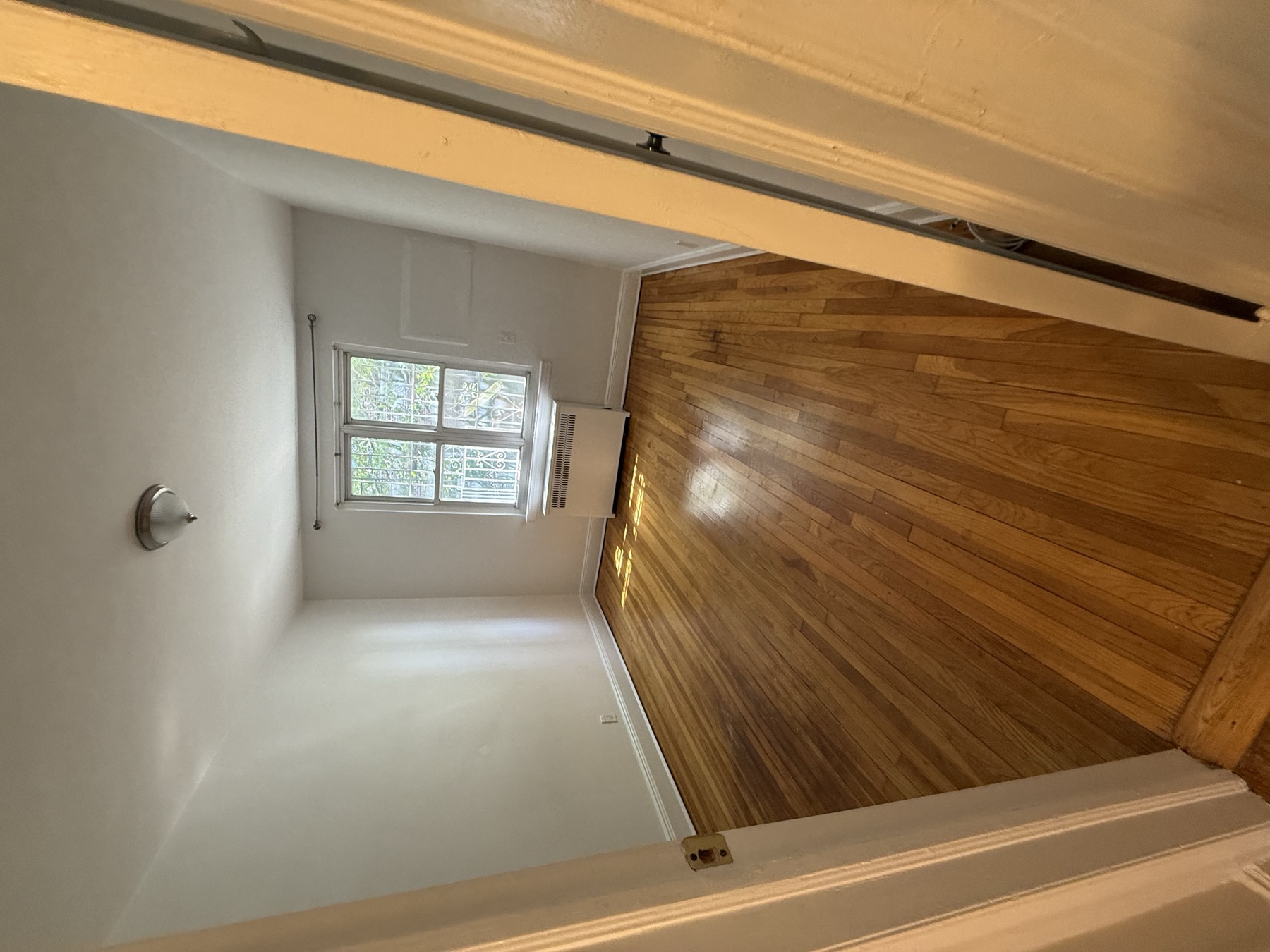 Clean bedroom and hardwood floors after move-in cleaning in Queens, New York
